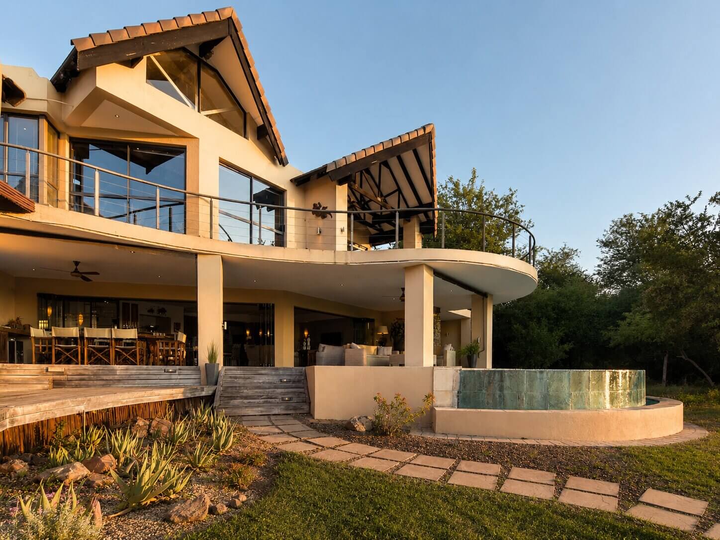 Covered patio with outdoor seating, an infinity pool and Crocodile River views at Impangele River Lodge.