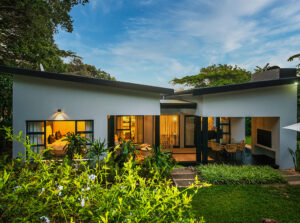 Modern exterior of Villa Albizia surrounded by landscaped gardens and lush greenery.